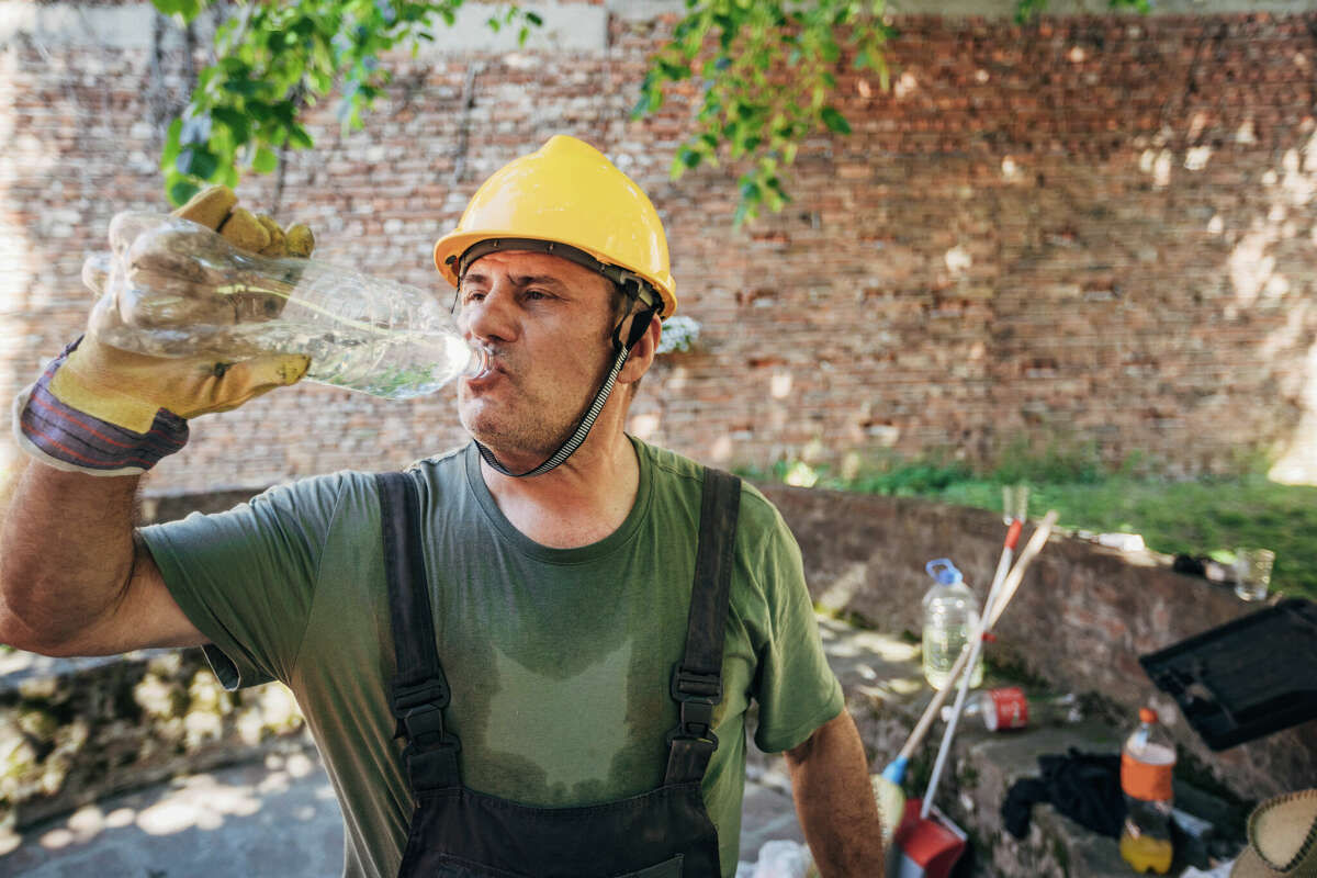 A construction worker drinking water